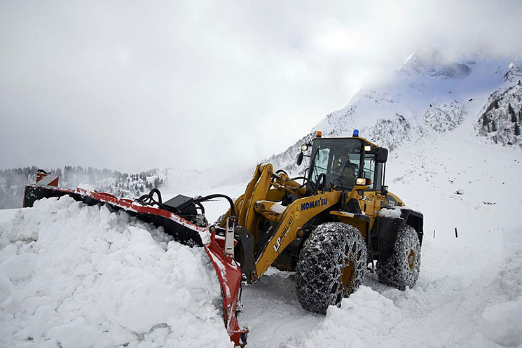 Engin de déneigement en action dans la neige en montagne