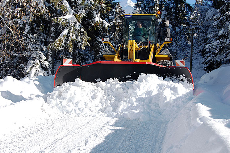 Engin de déneigement en action dans la neige en montagne