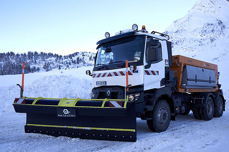 Engin équipé d'une lame SH en action sur une route enneigée