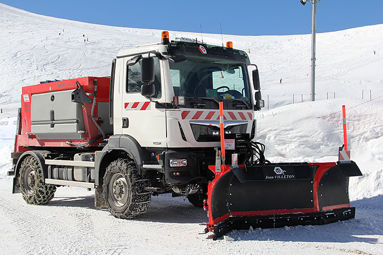 Engin équipé d'une lame tri-axiale sur une route enneigée